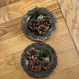 A set of decorative silver-plated dishes used as home decor with pine cones